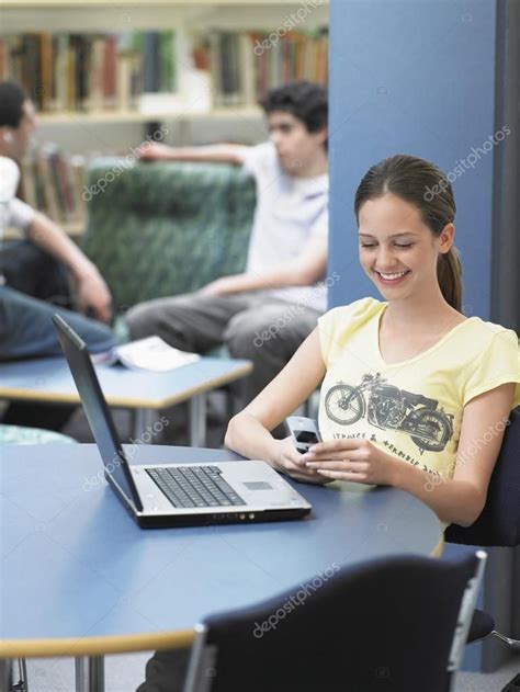 Girl Messaging In Library Royalty Free Stock Images
