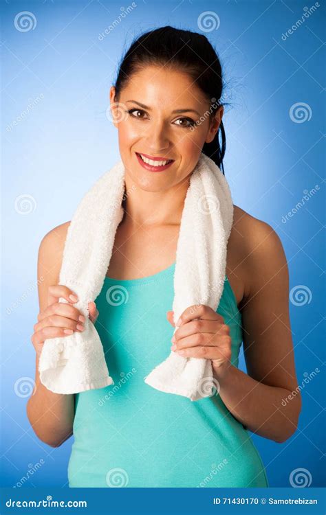 Woman Rests After Fitness Workout With Towel Around Her Neck Over Blue
