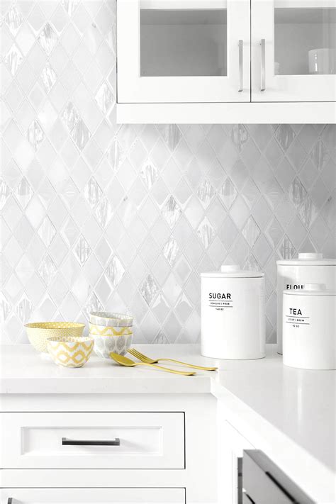 Add pops of color by pairing it with black mosaic tiles for a retro chic effect that will set your kitchen apart. Elegant White Rhomboid Backsplash Tile | Backsplash.com