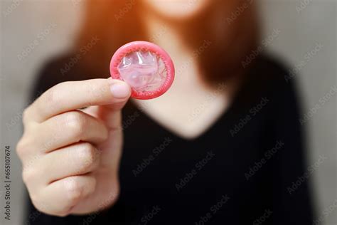 condom ready to use in female hand give condom safe sex concept on the bed prevent infection