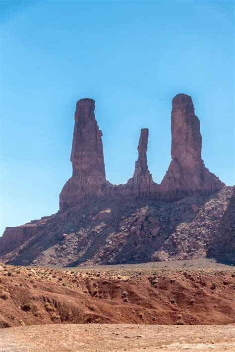 Red Rocks Of Monument Valley On A Clear Summer Day With Tree Trunk On