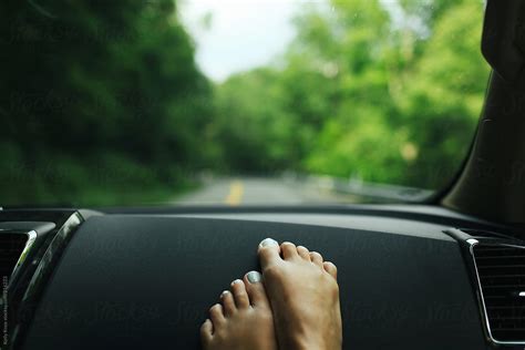 Womans Feet On The Dashboard Of A Car During A Road Trip By Stocksy