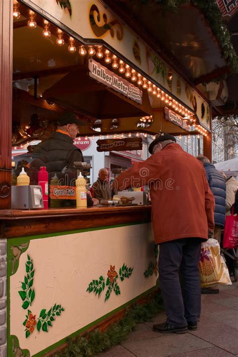 An Old Man Buying Some Food On A Christmas Market In
