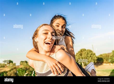 Two Girls Best Friends Having Fun Outdoor In A Green Nature Park
