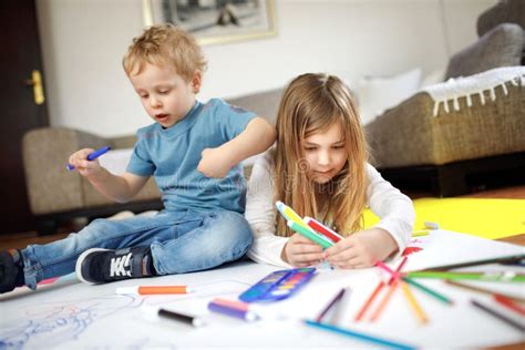 Two Kids Are Playing And Drawing On The Floor Stock Photo Image Of