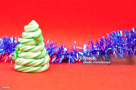 A Candy Cane Christmas Tree Displayed With Blue Tinsel On A Red