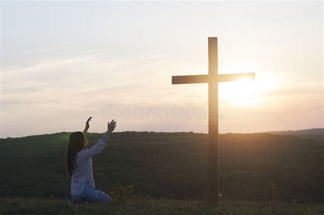 A Woman Is Kneeling With Her Hands Up Near The Cross Prayer Of