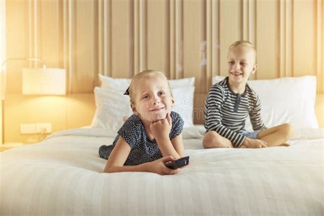 Cute Little Brother And Sister Watching Tv On A Bed Stock Image Image