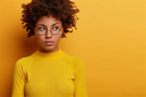 gros plan d une jeune mannequin contemplative porte des lunettes rondes et des vêtements jaunes