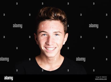 Cheerful Teenager Boy Face With Acne On Black Background Stock Photo