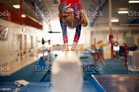 Young Gymnast Doing Handstand On Balance Beam Stock Photo Download