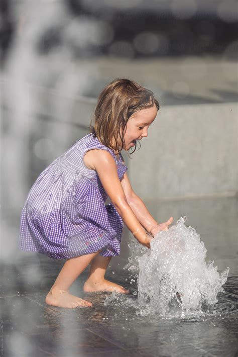 Portrait Of Wet Little Girl Playing At The Fountain By Stocksy