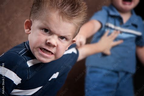 Angry Little Boy Glaring And Fighting With His Brother Stock Photo