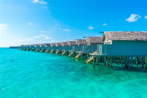 Water Villas Over Calm Sea In Tropical Maldives Island