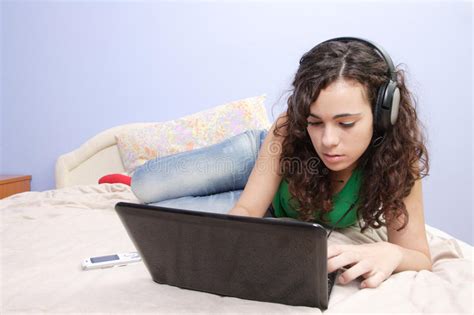 Het Meisje Dat Van De Tiener In Bed Op Haar Laptop Kijkt Stock