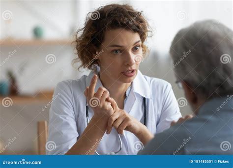 Female Physician Talking To Senior Patient At Visit In Hospital Royalty