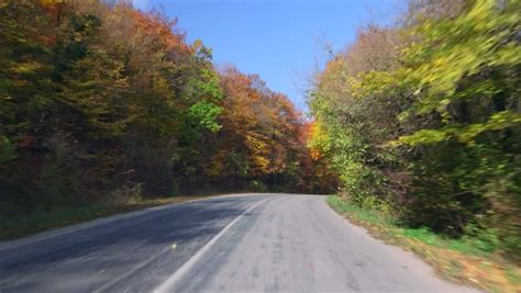 Car Driving On Winding Road Through Colorful Autumn Forest Pov Stock