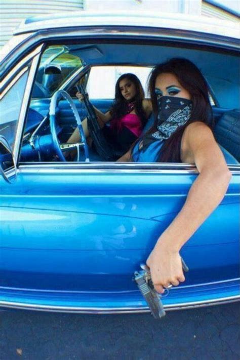 two women sitting in the driver s seat of a blue car