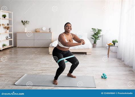 Full Length Of Curvy Black Woman Squatting With Elastic Band During