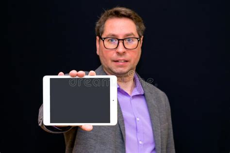 Middle Age Business Man Holding And Shows Tablet Pc With Blank Screen