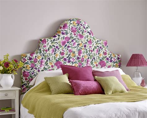 A Bed With Pink And Yellow Pillows On Its Headboard In A Bedroom
