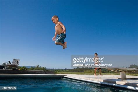 Boy Jumping Off Diving Board Into Pool Photo Getty Images