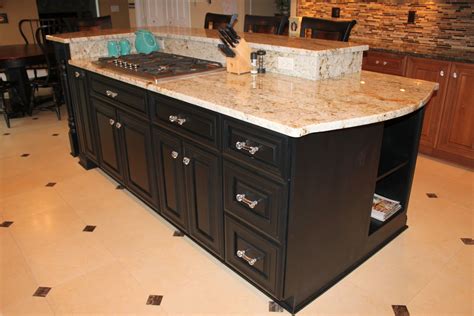 Black Island With Granite Countertop And A Bookshelf On One End
