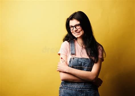 Beautiful Smiling Brunette Girl Wearing Glasses In Denim Overall Posing