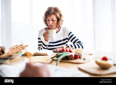 Senior Woman Eating Breakfast At Home Stock Photo Alamy