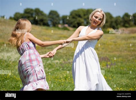 Mother And Daughter Dancing In A Meadow Stock Photo Alamy