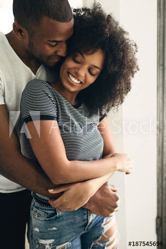 Young Black Couple Embracing At Home Buy This Stock