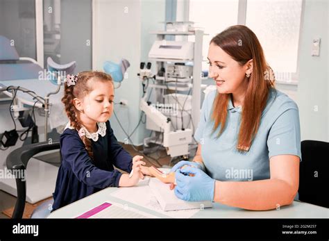 Female Gynecologist In Sterile Gloves Explaining Anatomy To Cute Little