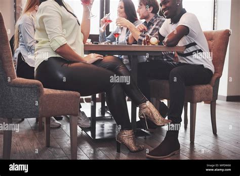 Girl Flirting With A Guy Touching Leg Her Foot Under The Table In A Cafe While Having Fun With