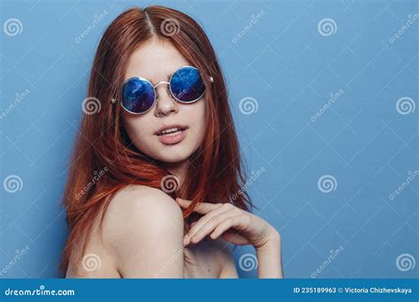 Perky Red Haired Woman In Blue Glasses Bare Shoulders Posing Stock
