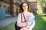 University student girl looking happy smiling with book or notebook in ...