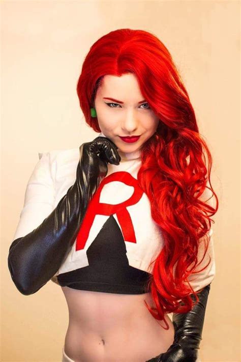 a woman with long red hair and black gloves on her chest is posing for the camera