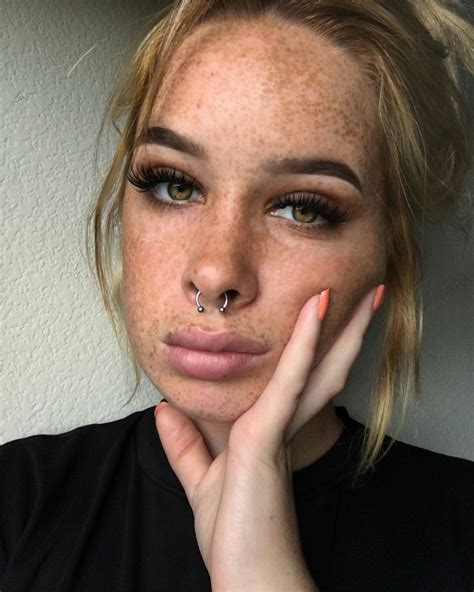 A Woman With Freckled Hair And Piercing On Her Nose Looking At The Camera