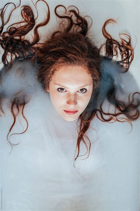 Portrait Of A Beautiful Redhead With Freckles Having A Milk Bath Del Colaborador De Stocksy