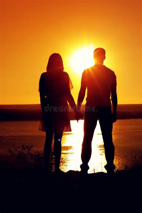 Silhouette Of Man And Woman Near Sea At Sunset Stock Photo Image Of
