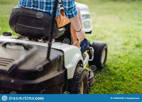 Portrait Of Gardener Using A Lawn Mowing Tractor For Cutting Grass