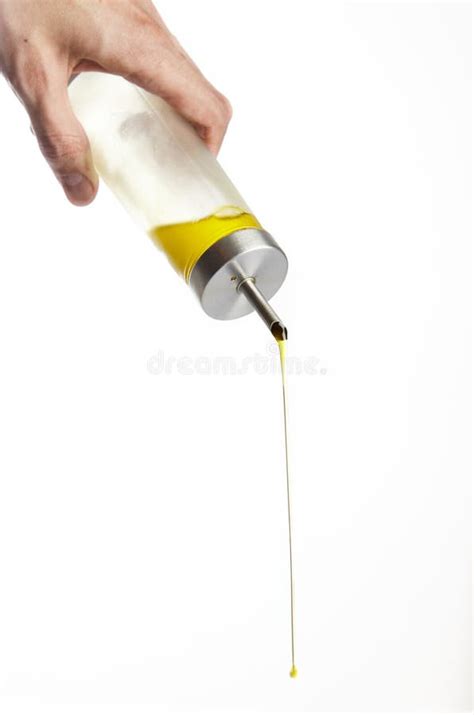 Hand Pouring Olive Oil From Glass Bottle On White Background Stock