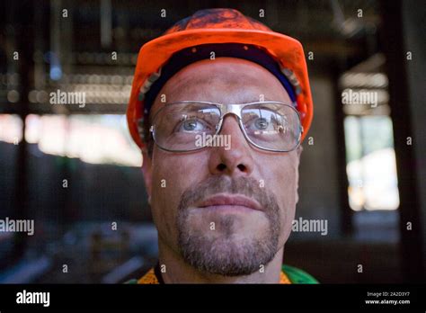 Dirty Mid Adult Construction Worker Wearing A Helmet And Safety Glasses