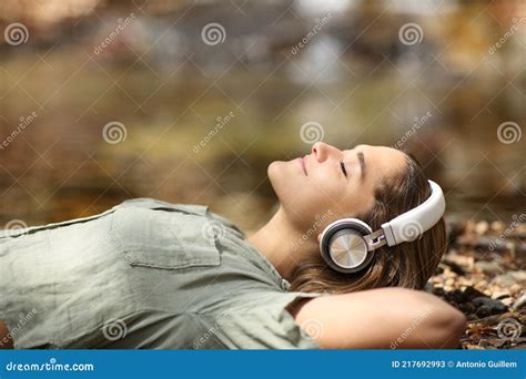 Woman Listening To Music Lying In A Riverside Stock Image Image Of