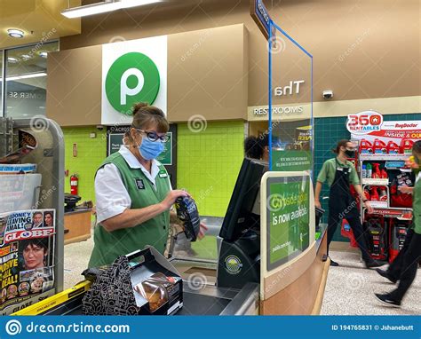 A Publix Grocery Store Employee Wearing A Face Mask And Behind A