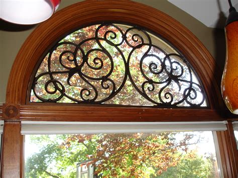 Front doors that are half glass panes can be a security risk. Iron Art in half round above window. | Arched window ...