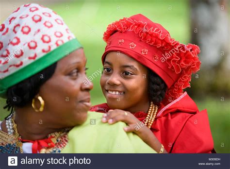 Suriname women are simply gorgeous. Suriname, Paramaribo. Creole woman and girl in Kotomisi ...