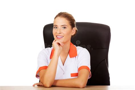 Smile Female Doctor Or Nurse Sitting Behind The Desk Stock Photo