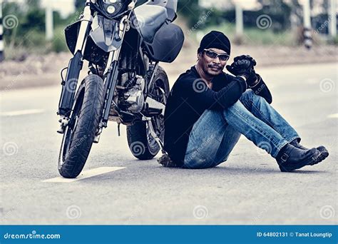 Biker Relax Sitting With Motorbike On Road In Sunset Stock Image