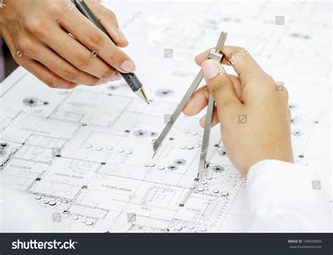 Architect Reviewing Blueprint By Adjusting Drawing Stock Photo Edit