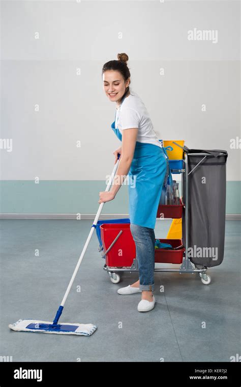 Happy Young Female Janitor With Cleaning Equipment Stock Photo Alamy